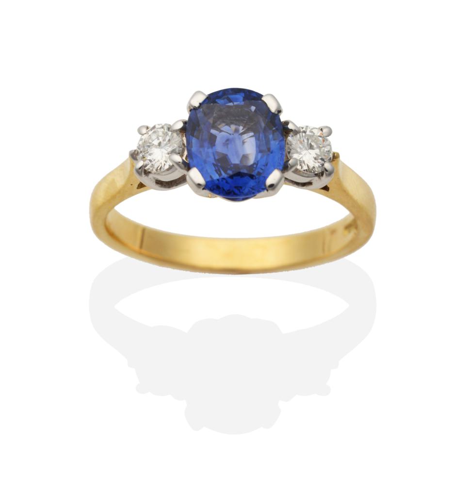 Lot 356 - An 18 Carat Gold Sapphire and Diamond Three Stone Ring, an oval cut sapphire spaced by round...