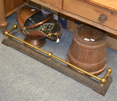 Lot 1061 - A copper coal scuttle, a brass and cast iron fender, a trivet and a treen spice container