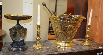 Lot 1063 - A Victorian brass coal scuttle, pokers, scales and a pair of brass candlesticks