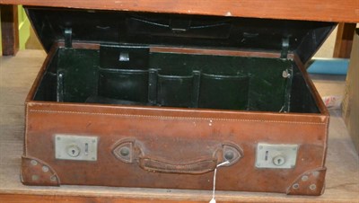 Lot 1098 - An early 20th century leather suitcase / travelling trunk with a green leather interior and...