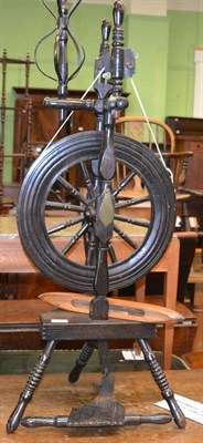 Lot 1316 - A wooden spinning wheel with a shuttle