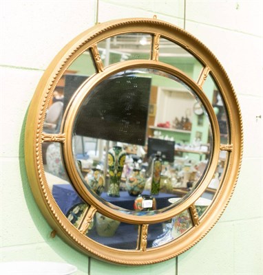 Lot 1378 - An oval sectional gilt mirror