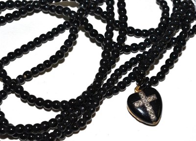 Lot 68 - A rose cut diamond and black enamel heart locket pendant, on long jet bead necklace (enamel a.f.)