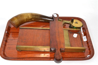 Lot 183 - A brass plate wind fishing reel, a mahogany pill roller and a Sykes powder horn (3)