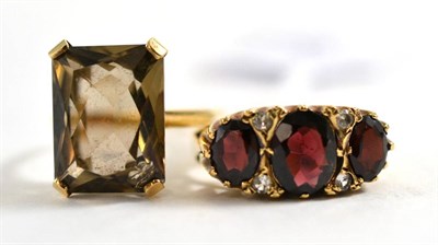 Lot 421 - A 9ct gold smokey quartz ring and a 9ct gold garnet and diamond ring (2)