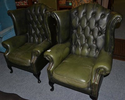 Lot 1114 - A pair of reproduction button back wing chairs