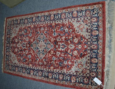 Lot 1117 - Indian silk rug, the brick red field of scrolling vines around a diamond medallion enclosed by...