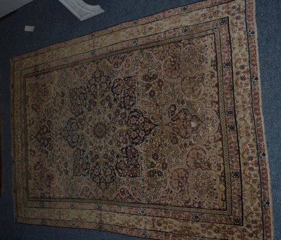 Lot 1153 - Kirman rug, South East Iran, the ivory field of scrolling vines centred by an indigo flowerhead...