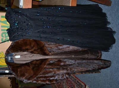 Lot 1235 - A brown mink fur coat with shawl type collar and cuffed sleeves, and a black net strapless...