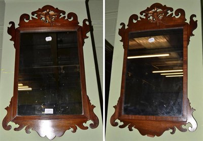 Lot 1251 - A pair of mahogany fret work mirrors, each surmounted by a gilt hoho birds