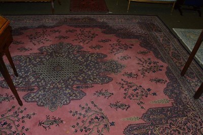 Lot 1295 - A machine made carpet, the coral pink field with central floral panel enclosed by cartouche border