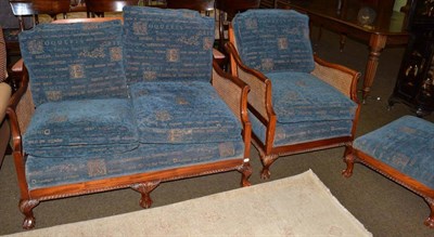 Lot 1317 - A modern mahogany framed bergere settee, chair and footstool, with blue upholstered cushions (3)