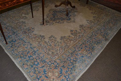 Lot 1334 - A Kirman Carpet, South East Iran, the plain ivory field centred by a pale indigo medallion...