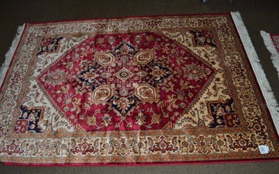 Lot 1391 - An artificial silk rug of Heriz design, the raspberry field with central medallion framed by...