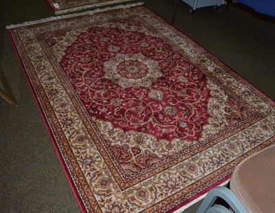 Lot 1392 - An artificial silk rug of Persian design, the raspberry field of vines centred by a roundel...