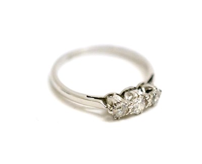 Lot 40 - A diamond three stone ring, graduated old cut diamonds in white claw settings on a pointed shoulder