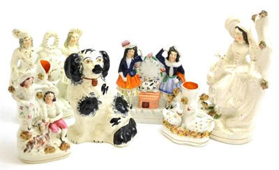 Lot 62 - Five Victorian Staffordshire pottery figure groups/spill vases and a similar spaniel figure (6)