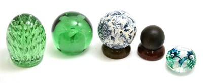 Lot 95 - Two green glass paperweights and a cannon ball on a stand, a transfer blue and white carpet...