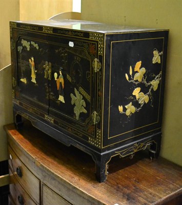 Lot 1237 - Chinoiserie lacquered low cabinet applied with hardstones