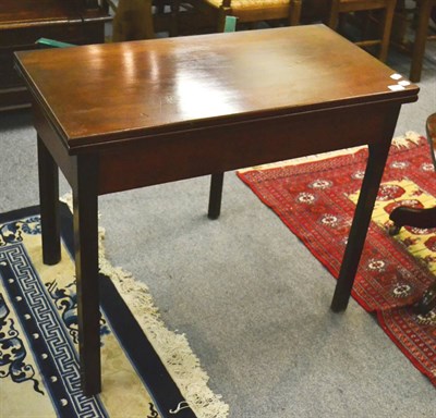 Lot 1266 - A George III mahogany fold over tea table, circa 1800, the rectangular hinged top above a plain...