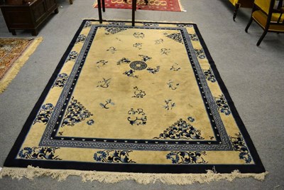 Lot 1271 - A Chinese carpet, the ivory field sparsely decorated with sprigs centred by a stepped roundel...