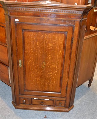 Lot 1329 - A George III oak straight fronted corner cupboard with painted interior with serpentine...