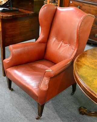 Lot 1353 - An early 20th century red leather wing armchair