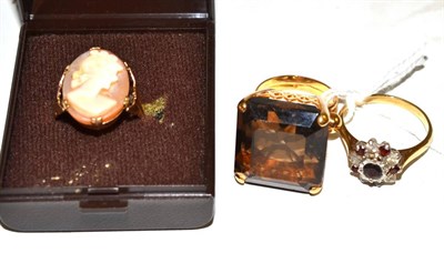 Lot 133 - A smoky quartz ring, a 9ct gold garnet and cubic zirconia cluster ring, a cameo ring, stamped '9ct'