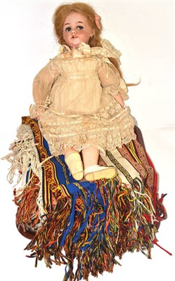Lot 167 - Bisque socket head doll with blue side glancing eyes, lace dress, bonnet and a tent hanging (2)