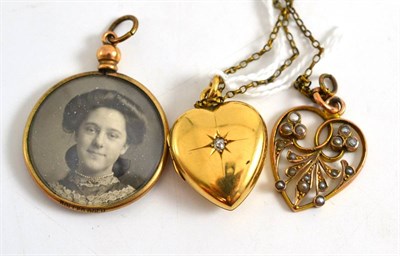 Lot 408 - A diamond set heart pendant, a seed pearl set pendant and a locket (3)