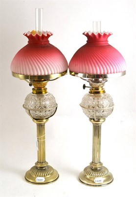 Lot 426 - A pair of Hukin and Heath silver plated oil lamps with cut glass fonts and peach coloured satin...