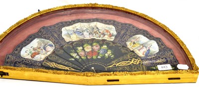 Lot 443 - An ebonised and painted fan in a glazed case