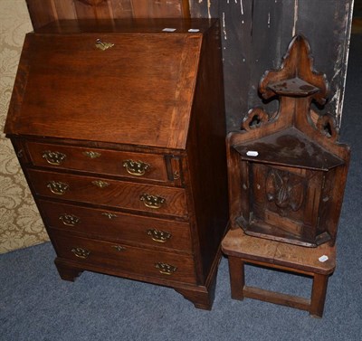 Lot 1031 - A narrow oak bureau, a corner cupboard carved with a dead snipe and a hall chair with a mermaid...