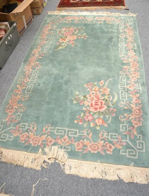 Lot 1074 - Chinese carved carpet, the plain field with naturalistic floral sprays to two spandrels enclosed by