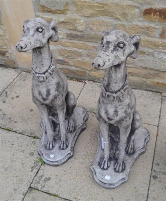 Lot 1119 - Pair of greyhounds seated on a shield shaped base, 81cm high