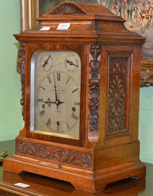 Lot 1201 - Russells Ltd chiming mantel clock in a carved oak case with silvered dial and presentation...