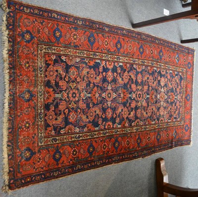 Lot 1214 - A Hamadan rug, Persian Kurdistan, the deep indigo herati field enclosed by madder borders, together