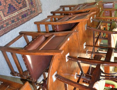 Lot 1240 - Reproduction oak dining table and eight matching chairs with leather and studded upholstery