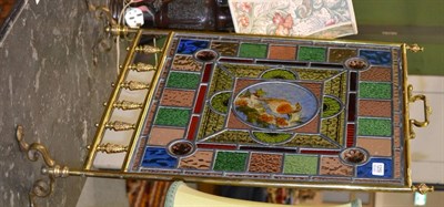 Lot 1259 - A Victorian brass fire screen with a leaded and stained glass panel, the central panel painted with