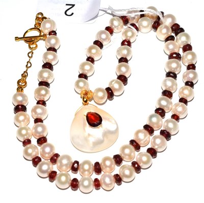 Lot 2 - A garnet and cultured pearl necklace with pendant drop, the cultured pearls spaced with faceted...