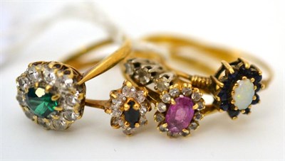 Lot 30 - A diamond three stone ring and four cluster rings (5)