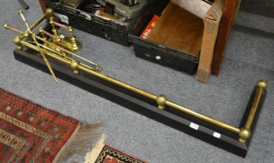 Lot 1078 - A brass mounted fender together with a matching set of andirons and fire implements (5)