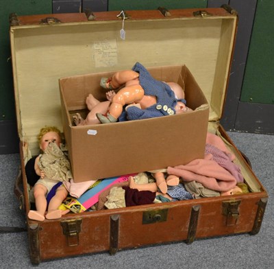 Lot 1107 - A trunk containing various plastic jointed dolls, AM 518 bisque head doll, two others (a.f.), dolls