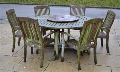 Lot 1124 - Teak garden furniture comprising six chairs, table, lazy susan and cushions