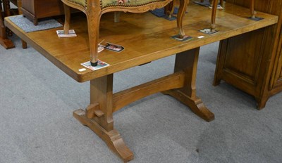 Lot 1210 - An English joined oak refectory style dining table, with adzed top and trestle platform base joined