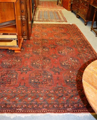 Lot 1260 - A 19th century Balouch rug, the deep indigo lattice field enclosed by hooked meandering vine...