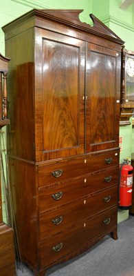 Lot 1319 - A Georgian mahogany two door cupboard over four drawers with swan neck pediment