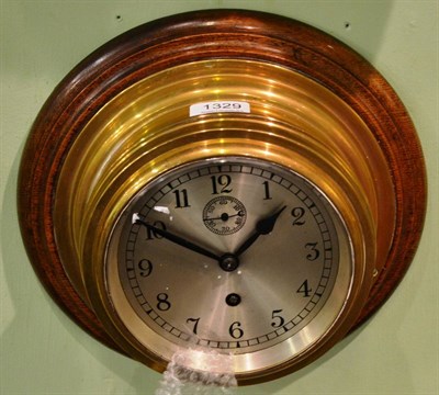 Lot 1329 - Brass cased wall clock on oak backboard