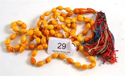 Lot 29 - A long strand of amber prayer beads with a tassel