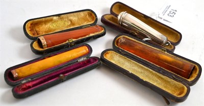 Lot 153 - Two amber cheroot holders with gold mounts, silver case and an amber cigar holder